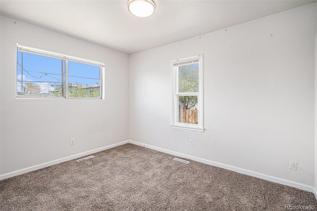 empty room with baseboards, carpet, and visible vents