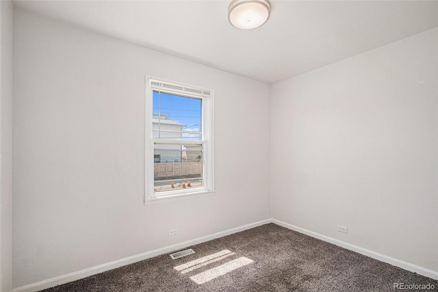 carpeted empty room featuring baseboards and visible vents