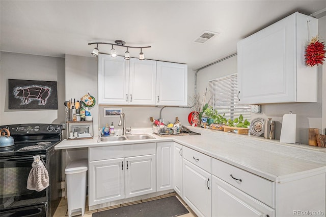 kitchen with visible vents, light countertops, white cabinets, black range with electric stovetop, and a sink