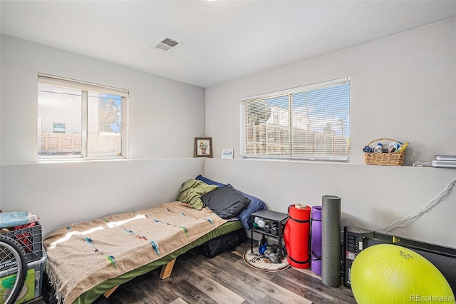 bedroom with visible vents and wood finished floors
