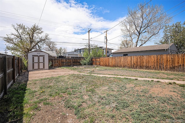 view of yard featuring an outdoor structure, a fenced backyard, and a shed