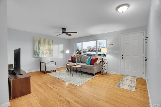 living room featuring ceiling fan and light hardwood / wood-style flooring