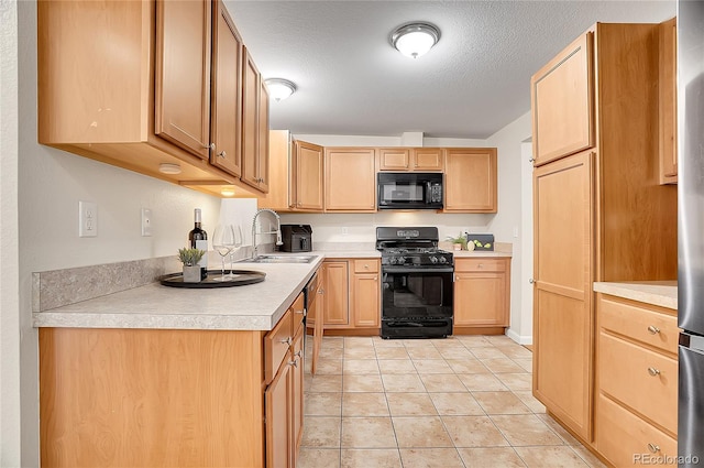 kitchen with sink, a textured ceiling, light brown cabinetry, light tile patterned flooring, and black appliances