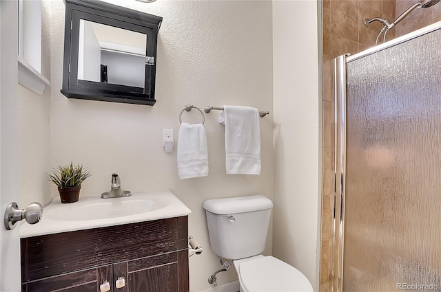 bathroom with vanity, toilet, and a shower with shower door