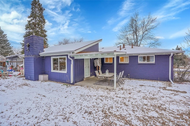 snow covered house with a patio area