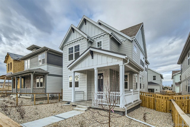 view of front of property featuring fence, a porch, and board and batten siding