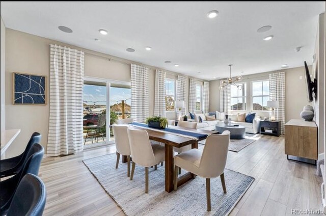 dining area featuring a chandelier, light wood-type flooring, and plenty of natural light