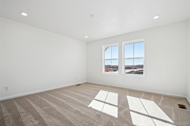 unfurnished room featuring light colored carpet