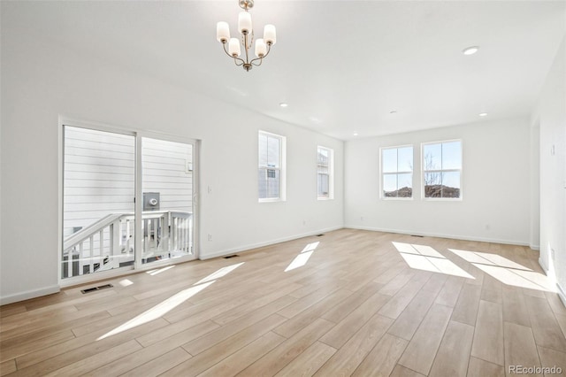 unfurnished living room with light hardwood / wood-style flooring and a notable chandelier