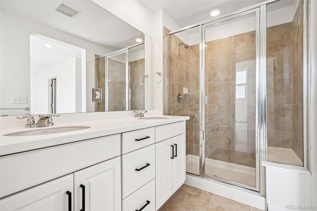 bathroom with tile patterned flooring, vanity, and a shower with door