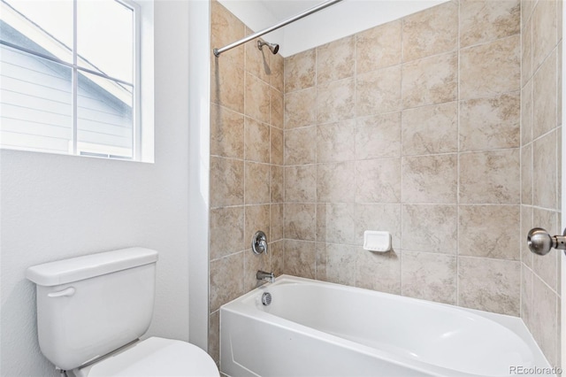 bathroom with tiled shower / bath and toilet