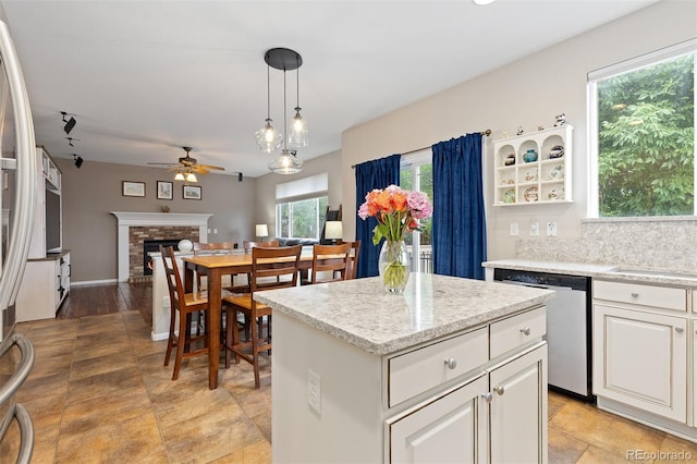 13753 Monroe St, Thornton, CO 80602 - kitchen with stainless steel appliances, a ceiling fan, a center island, a fireplace, and pendant lighting