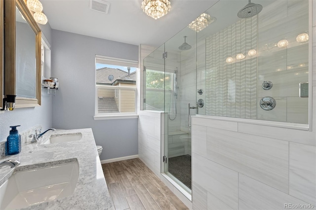 13753 Monroe St, Thornton, CO 80602 - full bath featuring wood finished floors, a shower stall, double vanity, and a chandelier