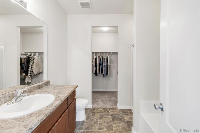481 Vista Blvd, Brighton, CO 80603 - full bathroom featuring toilet, vanity, a walk in closet, and baseboards