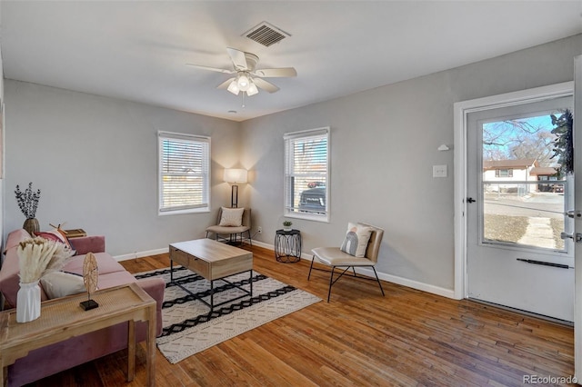 living room with visible vents, ceiling fan, and wood finished floors