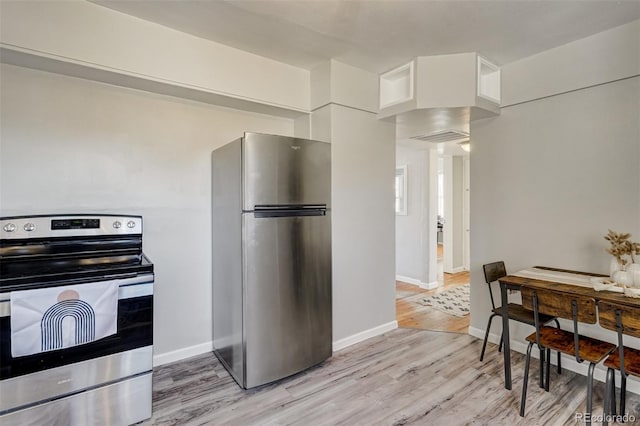 kitchen with light wood-type flooring, baseboards, stainless steel appliances, and white cabinets