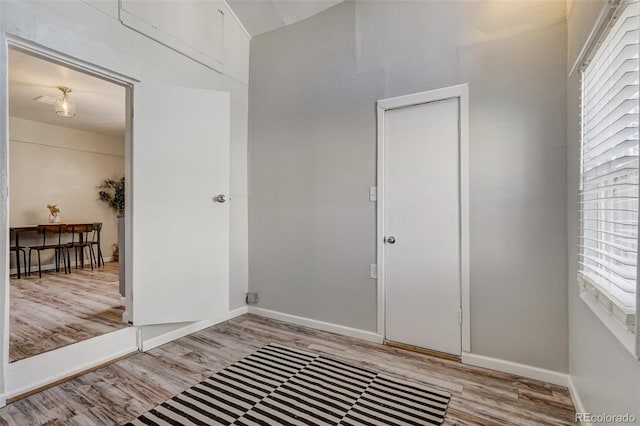 foyer entrance featuring light wood-style flooring and baseboards