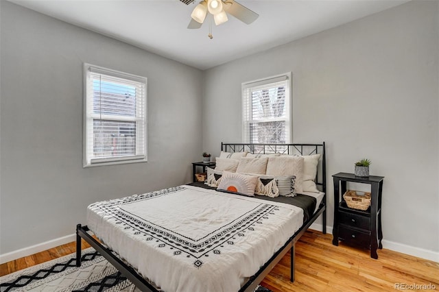 bedroom featuring ceiling fan, baseboards, and wood finished floors