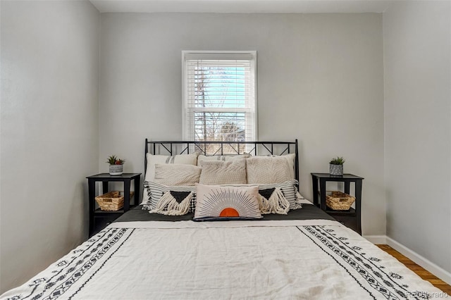 bedroom with baseboards and wood finished floors