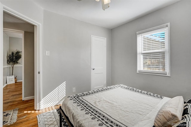 bedroom featuring ceiling fan, wood finished floors, and baseboards