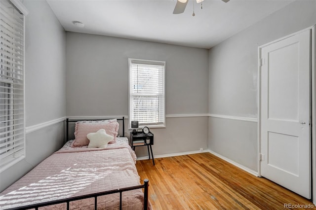 bedroom with wood finished floors, a ceiling fan, and baseboards