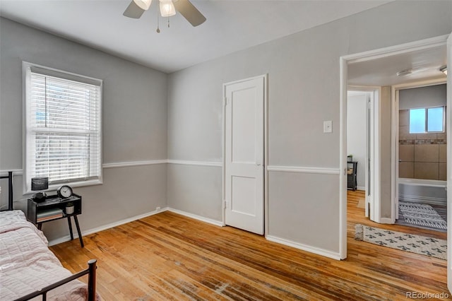 bedroom with a ceiling fan, baseboards, and wood finished floors