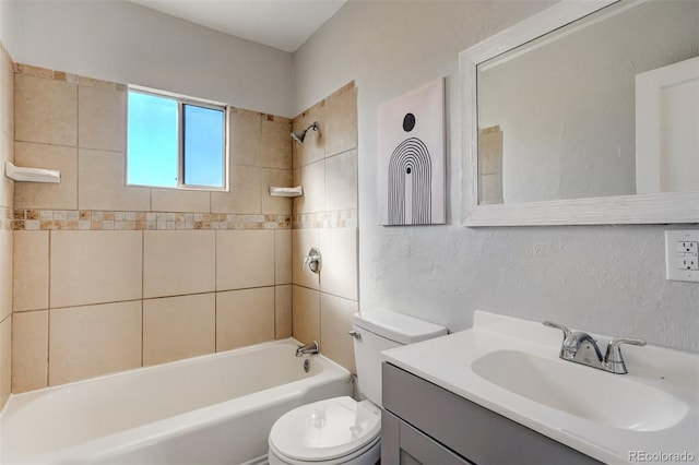 full bathroom featuring toilet, a textured wall, tub / shower combination, and vanity