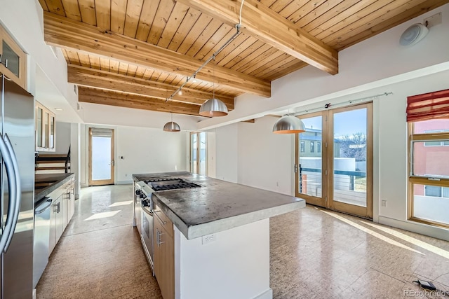 kitchen with dark countertops, appliances with stainless steel finishes, wood ceiling, a kitchen island, and beamed ceiling