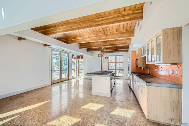 kitchen with dark countertops, wood ceiling, a sink, and beam ceiling