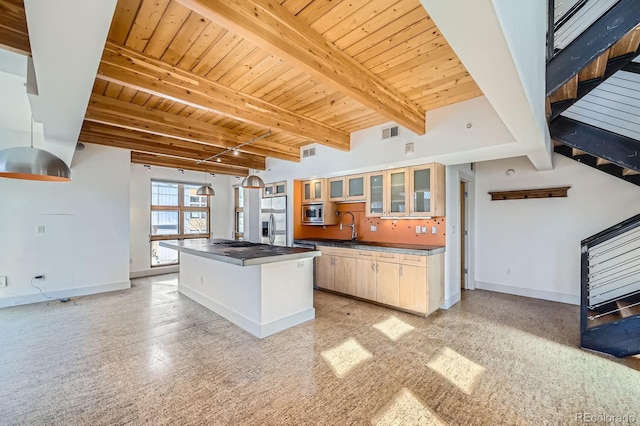 kitchen featuring beam ceiling, stainless steel appliances, a kitchen island, wooden ceiling, and baseboards