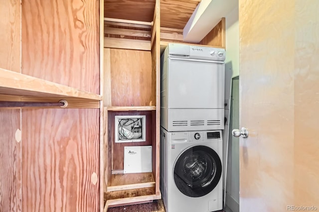 laundry room featuring stacked washer / drying machine and laundry area