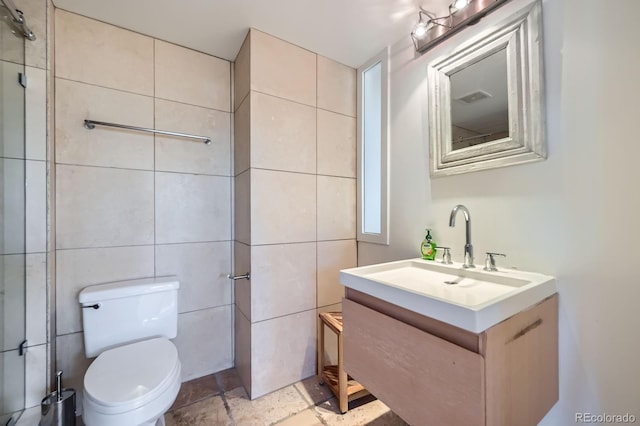 bathroom with toilet, visible vents, tile walls, and vanity