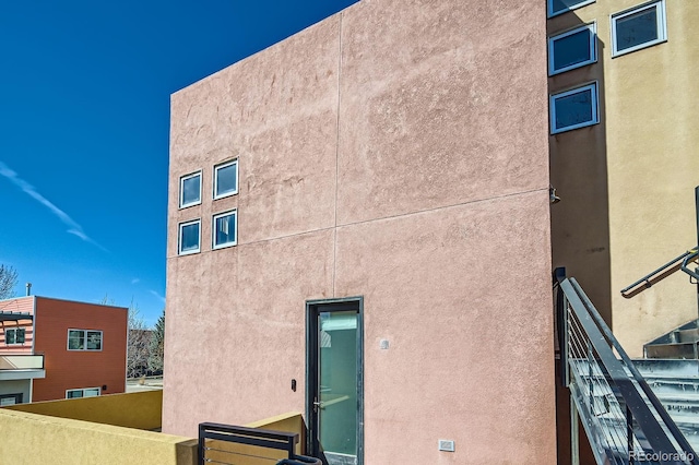 rear view of property with a balcony and stucco siding