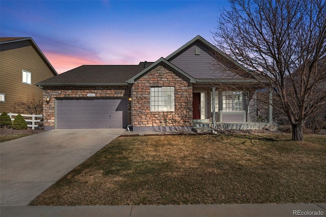 view of front of home featuring driveway, roof with shingles, an attached garage, stone siding, and a lawn