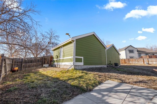 view of side of home with a lawn and cooling unit