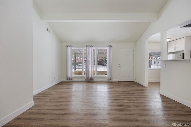 unfurnished living room featuring dark hardwood / wood-style flooring and lofted ceiling with beams