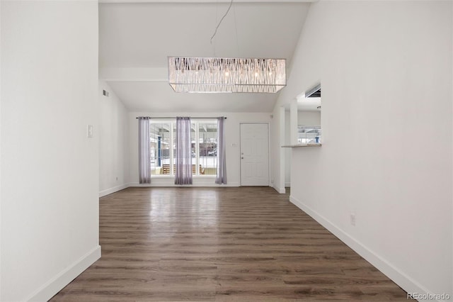 unfurnished living room featuring a chandelier, dark hardwood / wood-style floors, and high vaulted ceiling