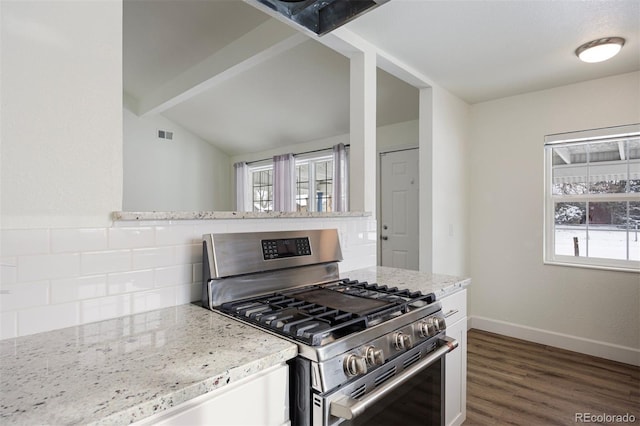 kitchen with gas range, light stone countertops, dark hardwood / wood-style floors, and vaulted ceiling with beams