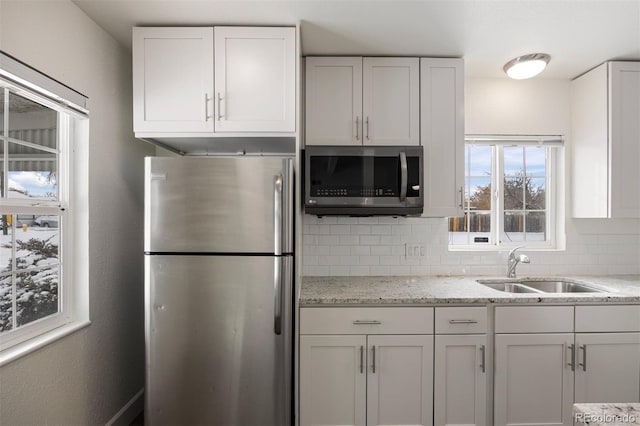 kitchen with white cabinetry, appliances with stainless steel finishes, and tasteful backsplash