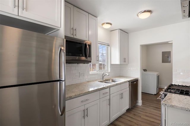 kitchen with sink, white cabinets, electric panel, washing machine and dryer, and stainless steel appliances