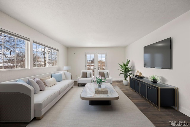 living room featuring dark wood-type flooring, a textured ceiling, and french doors