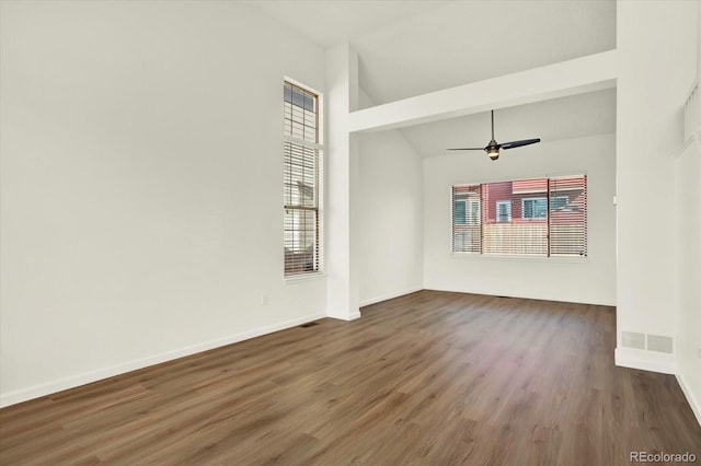 spare room featuring baseboards, a ceiling fan, plenty of natural light, and wood finished floors