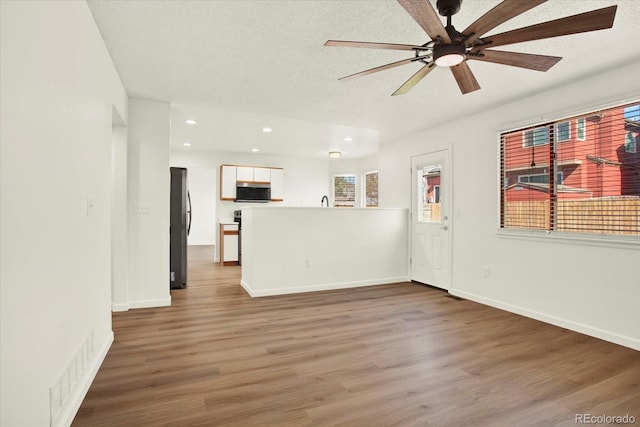 unfurnished living room featuring visible vents, wood finished floors, ceiling fan, and recessed lighting