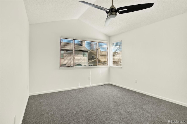 unfurnished room with a ceiling fan, dark carpet, a textured ceiling, baseboards, and lofted ceiling