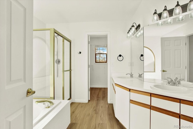 bathroom featuring a shower stall, a garden tub, and a sink