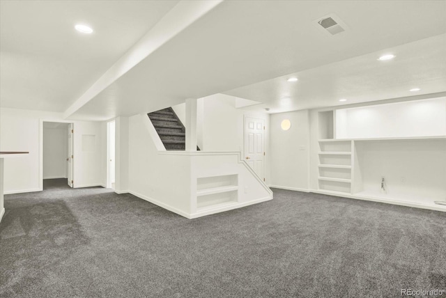 additional living space with baseboards, visible vents, and carpet