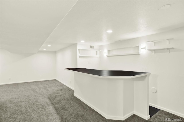 walk in closet with a bar and carpet