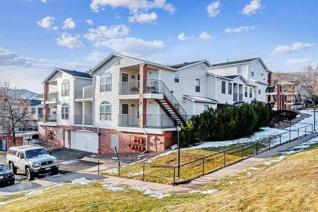 1648 S Cole St Unit B7, Lakewood, CO 80228 - view of building exterior featuring stairs, a garage, a residential view, and asphalt driveway