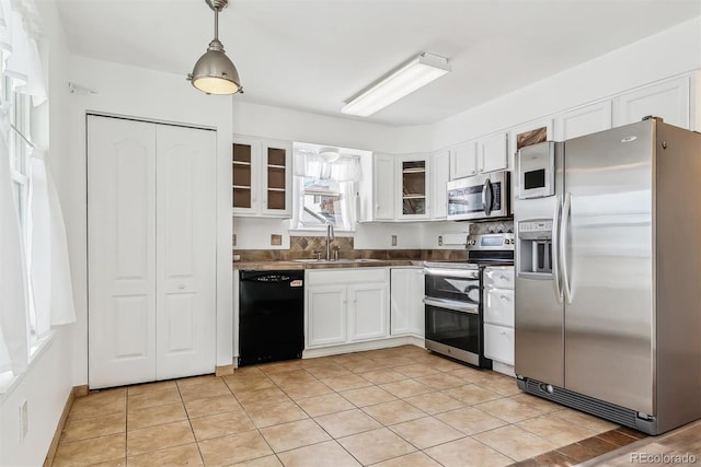 kitchen with pendant lighting, white cabinets, sink, appliances with stainless steel finishes, and light tile patterned flooring