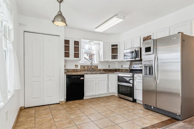 1648 S Cole St Unit B7, Lakewood, CO 80228 - kitchen with appliances with stainless steel finishes, white cabinetry, glass insert cabinets, hanging light fixtures, and dark countertops